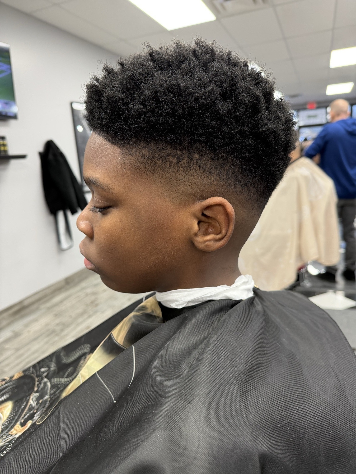 Taper fade texturizado con rizos arriba — X Express Barbershop
